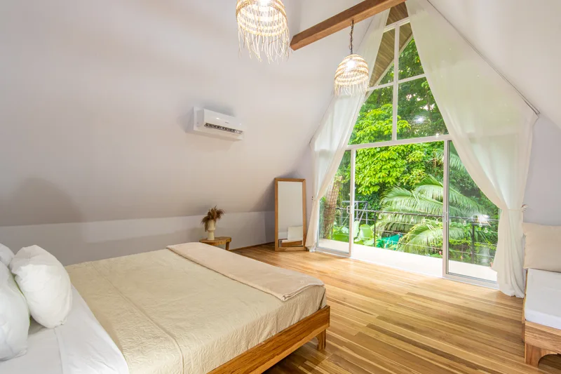 Crystal Jungle Villa loft bedroom with jungle canopy view through the A-frame window
